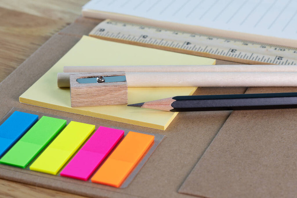 вибірковий фокус олівець для письма та різнокольоровий квадрат барвисті липкі ноти, лінійки та паперова книга про дерев'яний стіл концептуальне обладнання офісу та школи
 - Фото, зображення