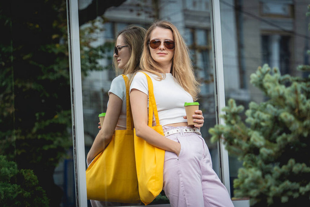 Young beautiful woman with linen eco bag on city background. - Fotó, kép