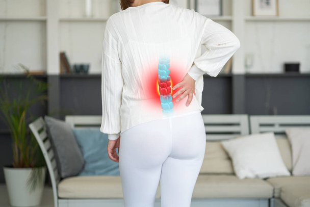 Lumbar intervertebral spine hernia, woman with back pain at home, spinal disc disease, health problems concept - Φωτογραφία, εικόνα
