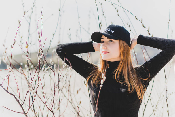 Woman wear black turtleneck, jeans and baseball cap, girl in sand desert. Fashionable casual style, fashion and clothes concept of modern look - Photo, Image