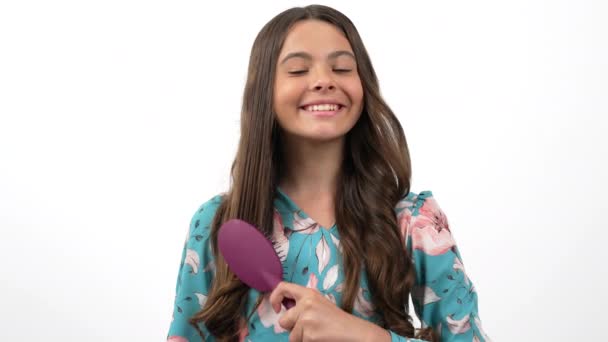 happy brunette kid combing beautiful wavy hair and showing clean hair brush, hair loss concept - Footage, Video