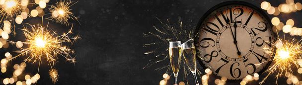 HAPPY NEW YEAR 2022 - Juhlava silvester Uudenvuodenaattona Party juhla tausta panoraama banneri pitkä - Golden keltainen ilotulitus, sparklers, kellon ja samppanjaa luokat paahtaminen pimeässä musta yö - Valokuva, kuva