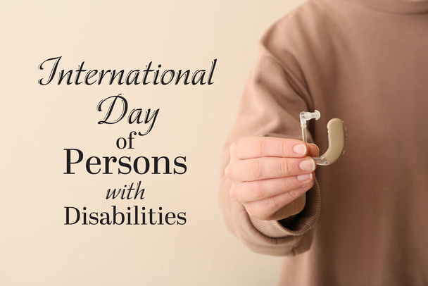 Femme avec prothèse auditive sur fond clair, gros plan. Journée internationale des personnes handicapées - Photo, image