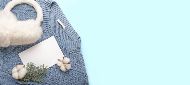 Пропущенная карточка со стильным зимним свитером и подогревом для ушей на синем фоне с местом для текста - Фото, изображение