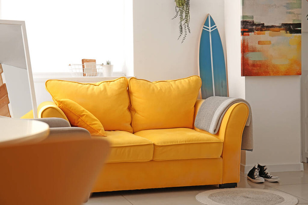 Belső tér elegáns modern szoba szörfdeszkával és kanapéval - Fotó, kép