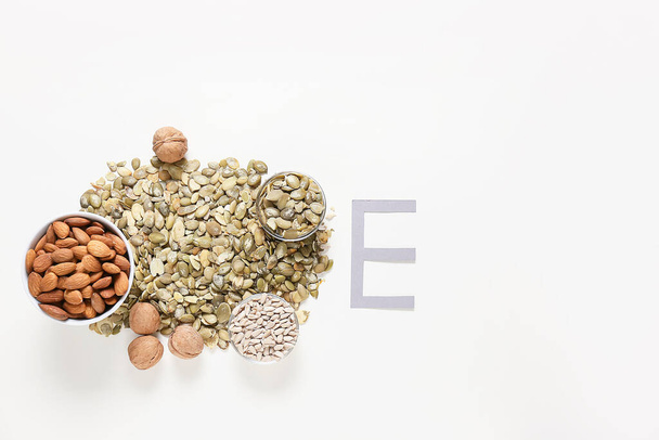 白い背景に異なるナッツと種を持つ手紙E - 写真・画像