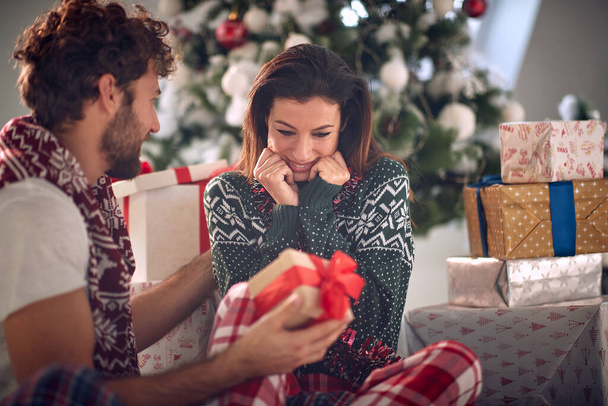  sharing gifts on Chrismas morning. Lovely man and woman enjoying together on Christma - 写真・画像