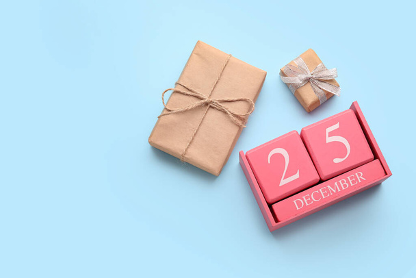 Календарь с датой Рождества и подарочные коробки на синем фоне - Фото, изображение