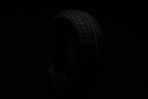 schwarzer Reifen auf schwarzem Hintergrund - Foto, Bild
