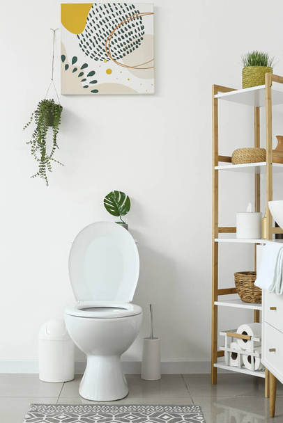 トイレボウルと棚ユニット付きの白いトイレのインテリア - 写真・画像