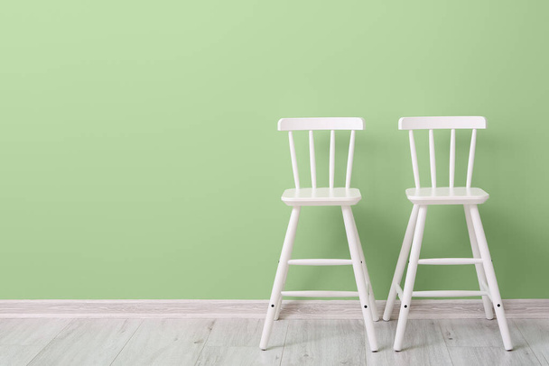 Cadeiras brancas para crianças perto de parede verde - Foto, Imagem