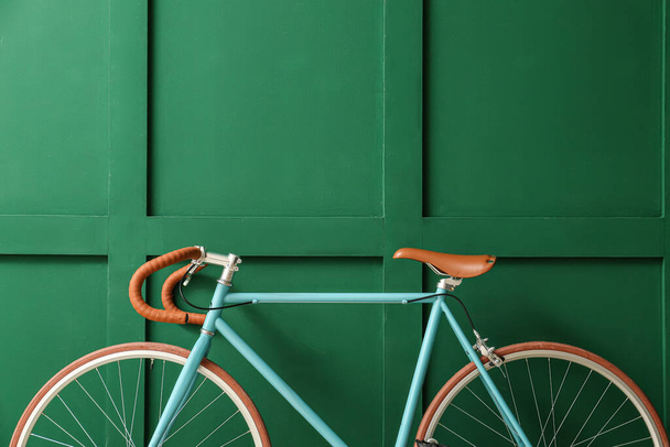 Стильный велосипед возле зеленой стены - Фото, изображение