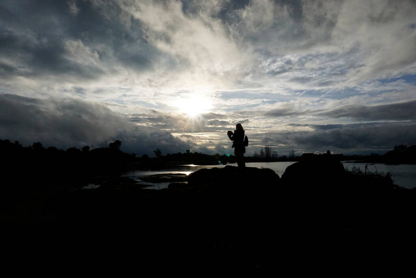 Retroiluminación de una mujer tomando fotos en la zona granítica de Los Barruecos en Extremea dehesa - Foto, imagen