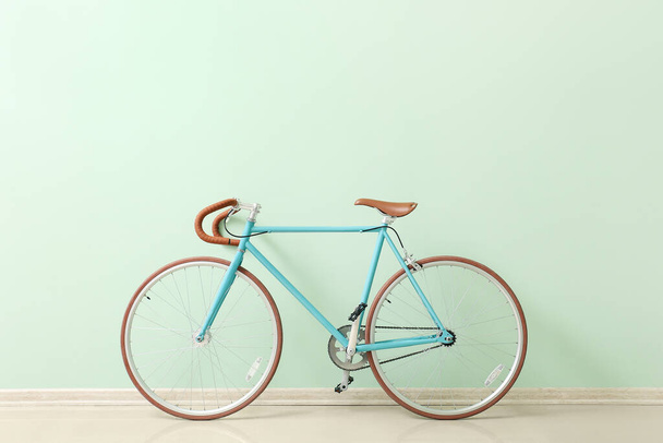 Elegante bicicleta cerca de la pared verde - Foto, imagen