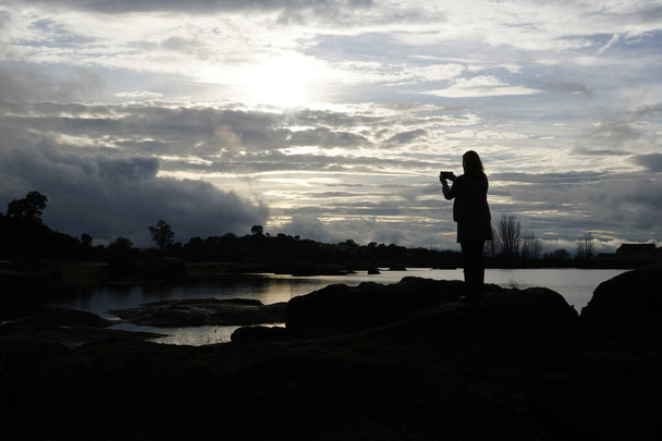Rétroéclairage d'une femme prenant des photos dans la zone granitique de Los Barruecos dans l'Extremea dehesa - Photo, image