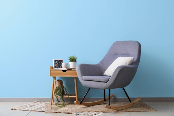 Άνετη πολυθρόνα και τραπέζι κοντά στον τοίχο χρώμα στο εσωτερικό του σαλονιού - Φωτογραφία, εικόνα