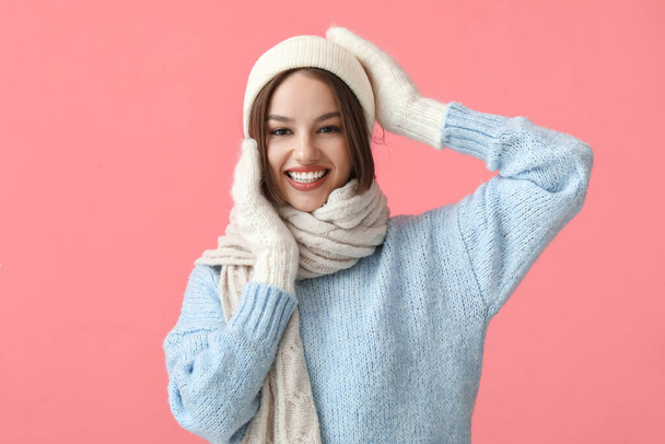 Young woman in stylish winter clothes on color background - Foto, afbeelding