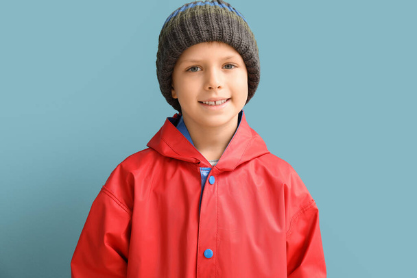 Little boy in raincoat on color background - Foto, imagen