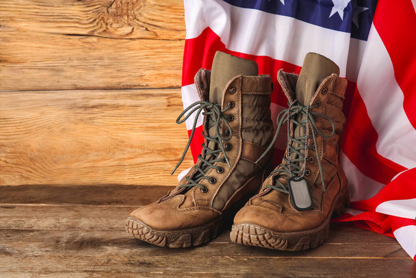 Military boots, tag and USA flag on wooden background - Fotoğraf, Görsel
