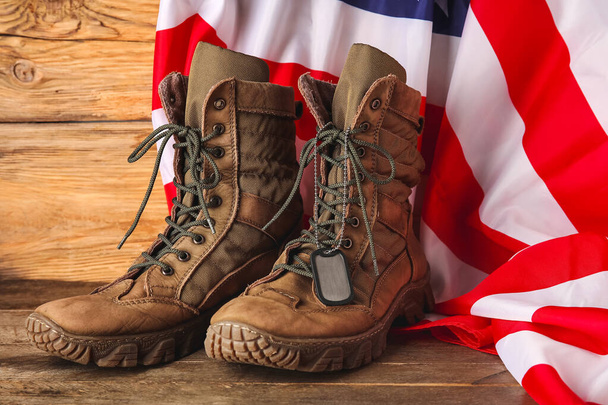 Military boots, tag and USA flag on wooden background - Foto, Imagem