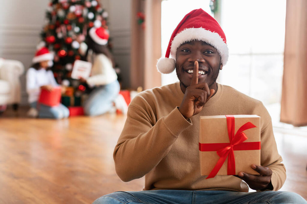 Geheimes Geschenk. Glücklicher schwarzer Kerl feiert Weihnachten - Foto, Bild