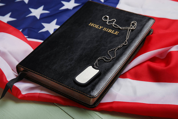 Bible, étiquette militaire et drapeau des États-Unis sur fond en bois - Photo, image