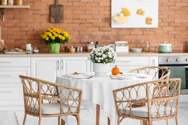 Обеденный стол с красивыми цветами Хризантемы в интерьере современной кухни - Фото, изображение
