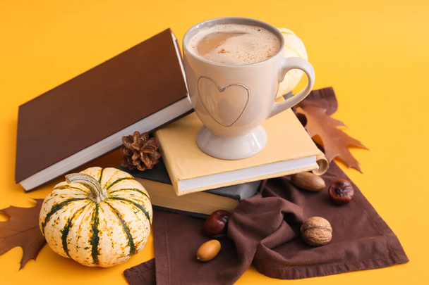 Kupa ízletes sütőtök kávé és könyvek sárga alapon - Fotó, kép