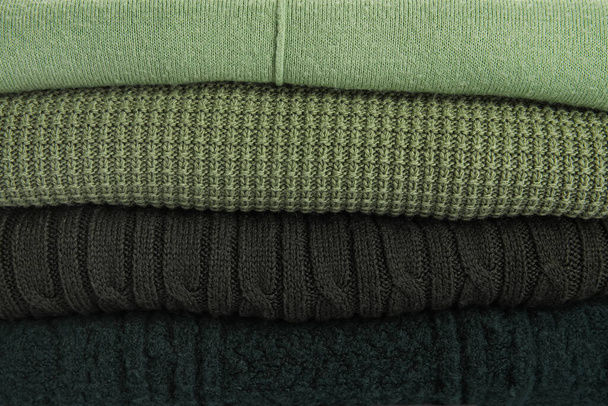 Pilha de camisolas verdes elegantes como fundo - Foto, Imagem