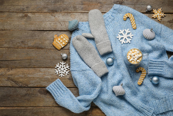 Stilvoller Winterpullover, Fäustlinge, Weihnachtsdekor, Tasse mit Kakao und Marshmallows auf Holzgrund - Foto, Bild