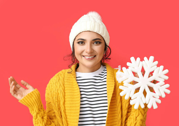 Smiling woman with beautiful snowflake on red background - Foto, afbeelding