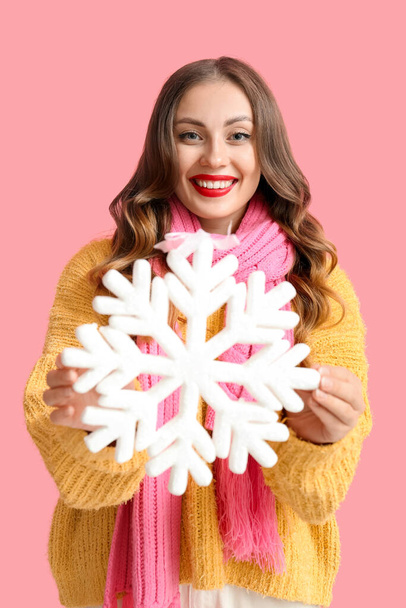 Happy woman with big snowflake on color background - Photo, Image