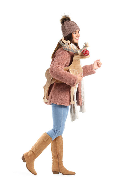 Walking young woman with wooden deer on white background - Foto, Imagem