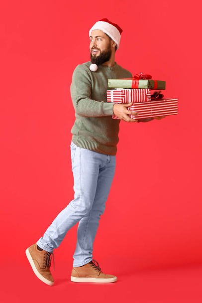 Περπάτημα άνθρωπος με δώρα Χριστουγέννων στο φόντο χρώμα - Φωτογραφία, εικόνα
