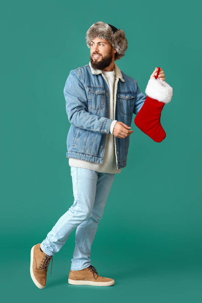 Περπάτημα άνθρωπος με κάλτσα Χριστουγέννων στο φόντο χρώμα - Φωτογραφία, εικόνα
