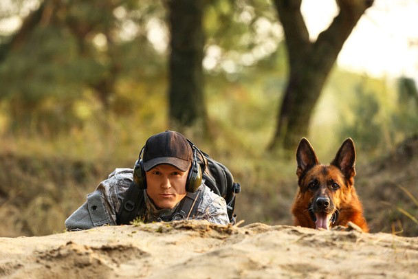 Voják s vojenským pracovním psem během bojové operace venku - Fotografie, Obrázek
