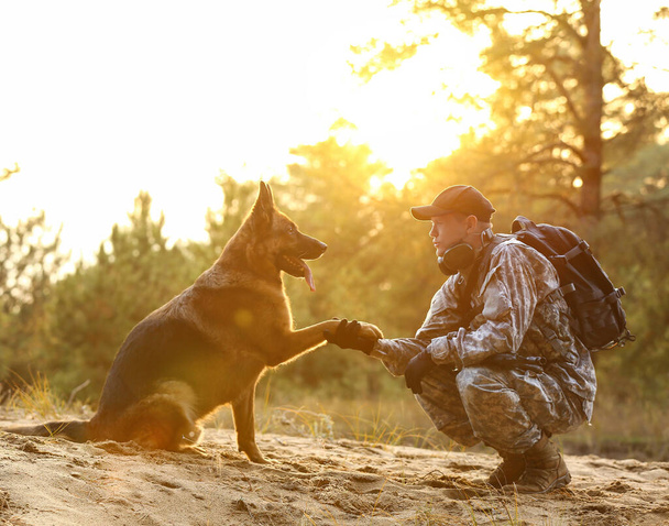 Militar cão de trabalho dando pata ao soldado ao ar livre - Foto, Imagem