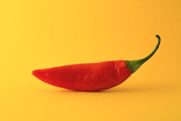Red chili pepper isolated on a yellow - 写真・画像