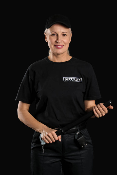 Female security guard with baton on dark background - Photo, Image