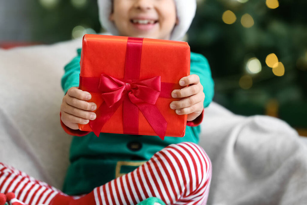 Милый мальчик с подарком дома в канун Рождества - Фото, изображение