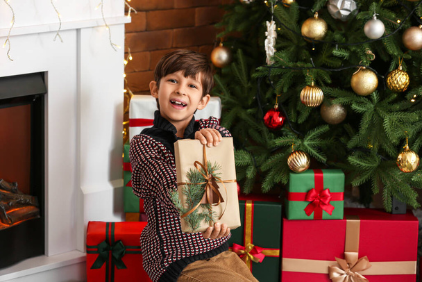 Cute little boy with gift at home on Christmas eve - Φωτογραφία, εικόνα