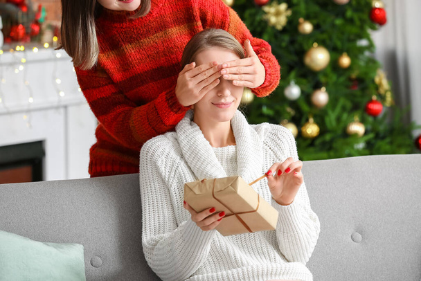 Young woman greeting her friend on Christmas eve at home - Photo, Image