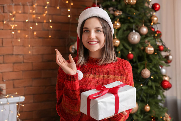 Bella giovane donna con regalo a casa la vigilia di Natale - Foto, immagini