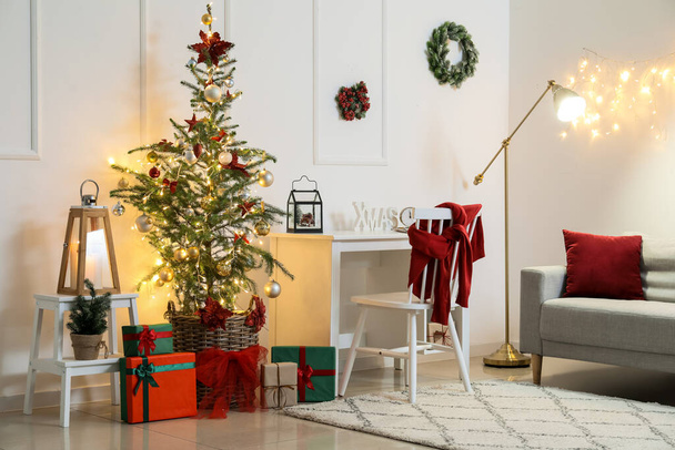 Εσωτερικό του δωματίου φως με σύγχρονο χώρο εργασίας, χριστουγεννιάτικο δέντρο και λαμπερά φώτα - Φωτογραφία, εικόνα