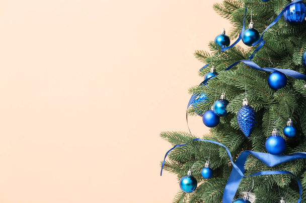 Beautiful Christmas tree with blue decor on beige background - Zdjęcie, obraz