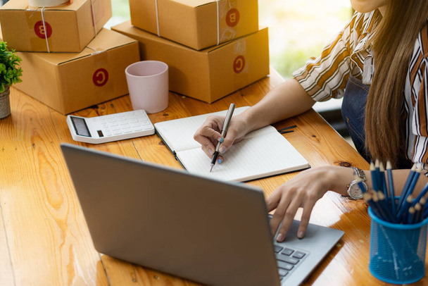 Digital online business is a small start-up for an online store. A young independent Asian SME concept working with cardboard boxes and laptops at work. online shopping delivery - Photo, Image