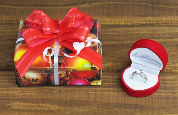 eine kleine Geschenkschachtel mit Ring auf Holztisch  - Foto, Bild
