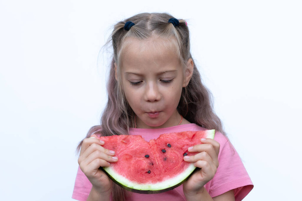 portret dziewczynki jedzącej arbuza, stojącej w różowej koszulce - Zdjęcie, obraz