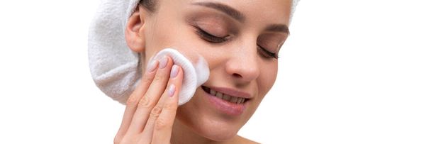 woman after shower with a cotton pad apply cream on her face skin care at the age of 30 plus - Φωτογραφία, εικόνα