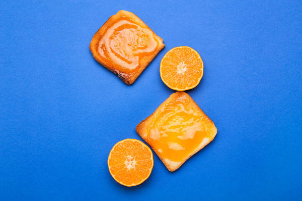 Mavi arka planda mandalina reçelli lezzetli tostlar - Fotoğraf, Görsel